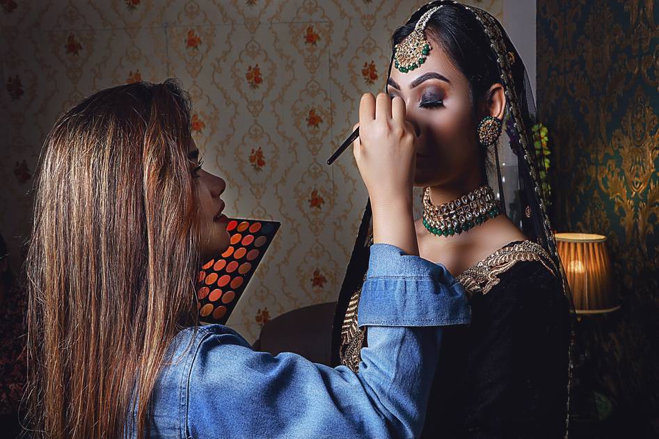 Elegant makeup competition stage with soft lighting and rose-gold palettes
